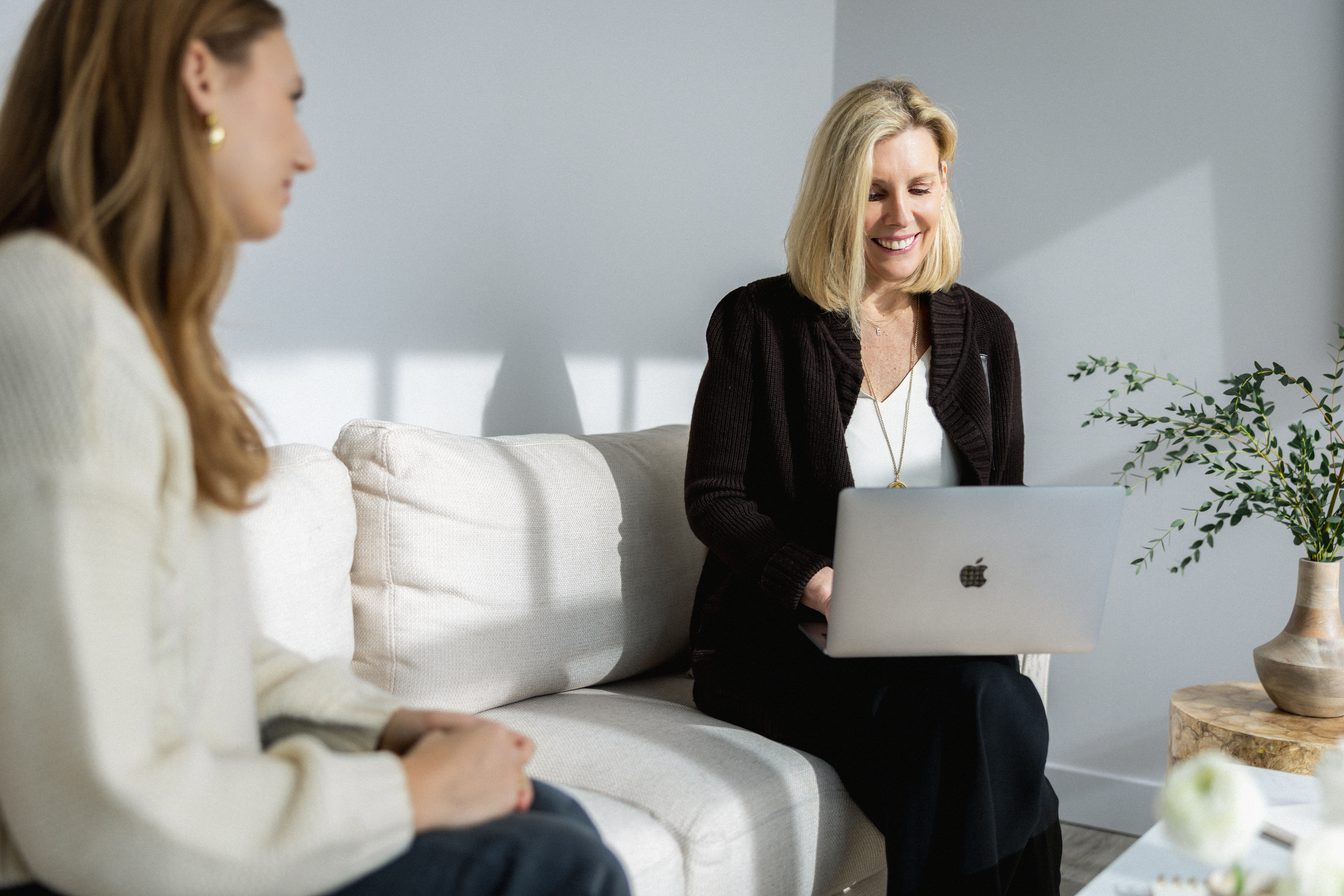 Elisabeth Tullis Schneider laughing with a client while holding a laptop